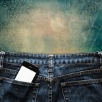 Blue Jeans With Cell Phone In Pocket Background Stock Photo