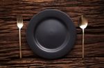 Black Empty Plate Fork Spoon On Wooden Table Background Stock Photo