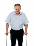 Senior Man Standing With Crutches Stock Photo