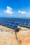 Rows Of Solar Panels Near Sea With Blue Sky Stock Photo