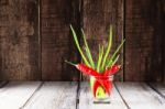 Red Hot Chilli Peppers And Green Onions In Glass Of Water Stock Photo