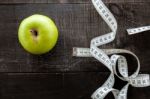 An Apple Surrounded By A Measuring Tape Tailor On Wood Stock Photo