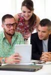 Casual Executives Working Together At A Meeting With Digital Tab Stock Photo