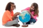 Young Girls Locating Countries On Globe Stock Photo