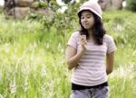 Woman Outdoors Holding Flower Smiling Stock Photo