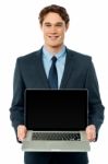 Corporate Executive Showing Laptop To Camera Stock Photo