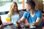 Group Of Friends Using Mobile Phone In Cafe Stock Photo