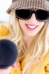 Lady Wearing Sunglasses Holding Mic Stock Photo