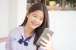 Portrait Of Thai Student Teen Beautiful Girl Using Her Phone And Smile Stock Photo