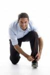 Young Good Looking Man Tying His Shoelace Stock Photo