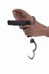 Woman's Hand With Handcuffs And Gun On A White Background Stock Photo