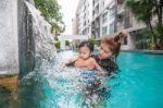 The Kid And Mom Play Together In The Pool Stock Photo