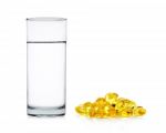 Water Of Glass With Fish Oil Capsules Isolated On The White Back Stock Photo