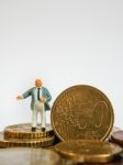 Miniature Businessman Stand On Euro Coins And Book Bank. Busines Stock Photo