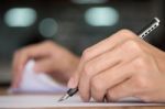 Businessman Writing In A Document. Focus On The Tip Of The Pen Stock Photo