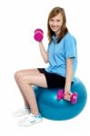 Pretty Teen Seated On A Blue Pilate Ball Doing Dumbbells Stock Photo