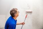 Worker Painting Wall With Background Glue For A Wallpaper Stock Photo