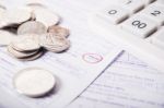 Utility Bill With Silver Coins And Calculator Stock Photo