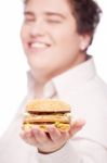 Hamburger In Hand Of A Chubby Man Stock Photo