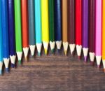 Multicolored Pencils On A Background Of Dark Wood Tables Stock Photo