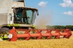 Combine Harvesting The Field Of Wheat On A Sunset Stock Photo