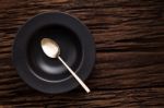 Black Empty Bowl Spoon On Wooden Table Background Stock Photo