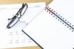 Workplace With Pen, Notebook, Glasses And Financial Report Stock Photo