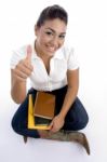 Sitting Girl Showing Thumbs Up Stock Photo