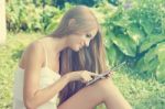 Beautiful Woman With Tablet Computer In Park Garden Stock Photo