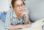 Beautiful Young Woman Reading A Book At Home Stock Photo