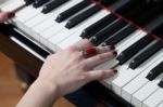 A Woman With Red Ring Playing Piano Stock Photo