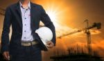 Engineer Man Standing With White Safety Helmet Against Beautiful Stock Photo