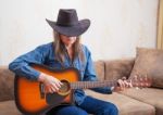 Elderly Man In A Hat Playing Guitar At Home Stock Photo