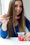 Young Beautiful Woman Eating Yogurt At Home Stock Photo