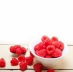 Bunch Of Fresh Raspberry On A Bowl And White Table Stock Photo