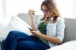 Pretty Young Woman Eating An Apple And Working At Home Stock Photo