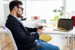 Handsome Young Man Using His Mobile Phone In The Office Stock Photo