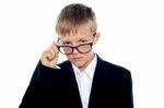 Young boy Removing Eyeglass Stock Photo