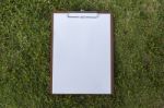 White Paper On Wooden Clipboard On Green Grass Background Stock Photo