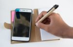 Mobile Phone Notebook And Pen On White Background Stock Photo