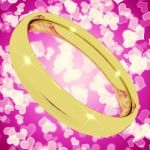 Golden wedding Ring On Pink Heart Stock Photo