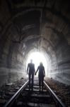 Couple Walking Together Through A Railway Tunnel Stock Photo