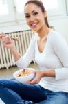 Beautiful Young Woman Eating Cereals At Home Stock Photo