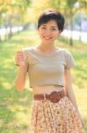 Portrait Of Young And Beautiful Asian Woman Standing In Park Wit Stock Photo