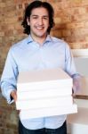 Smiling Man Holding Pizza Boxes Stock Photo