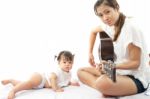 Mother Is Playing A Guitar For Her Baby Stock Photo