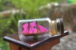 A Miniature Ship Inside The Bottle. In The Photo Very Close To A Charming Garden Background Stock Photo