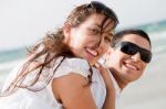 Young Couple Playing On Beach Stock Photo