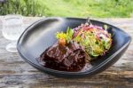 Grilled Rib Eye Beef Steak With Vegetable Salad In Black Bowl On Wood Table Stock Photo