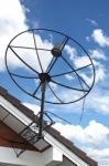 Satellite Dish Stuck To Roof Of House In Blue Sky Stock Photo